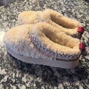 UGG Tazz Braid slippers in the "Heritage Braid Natural" colorway.